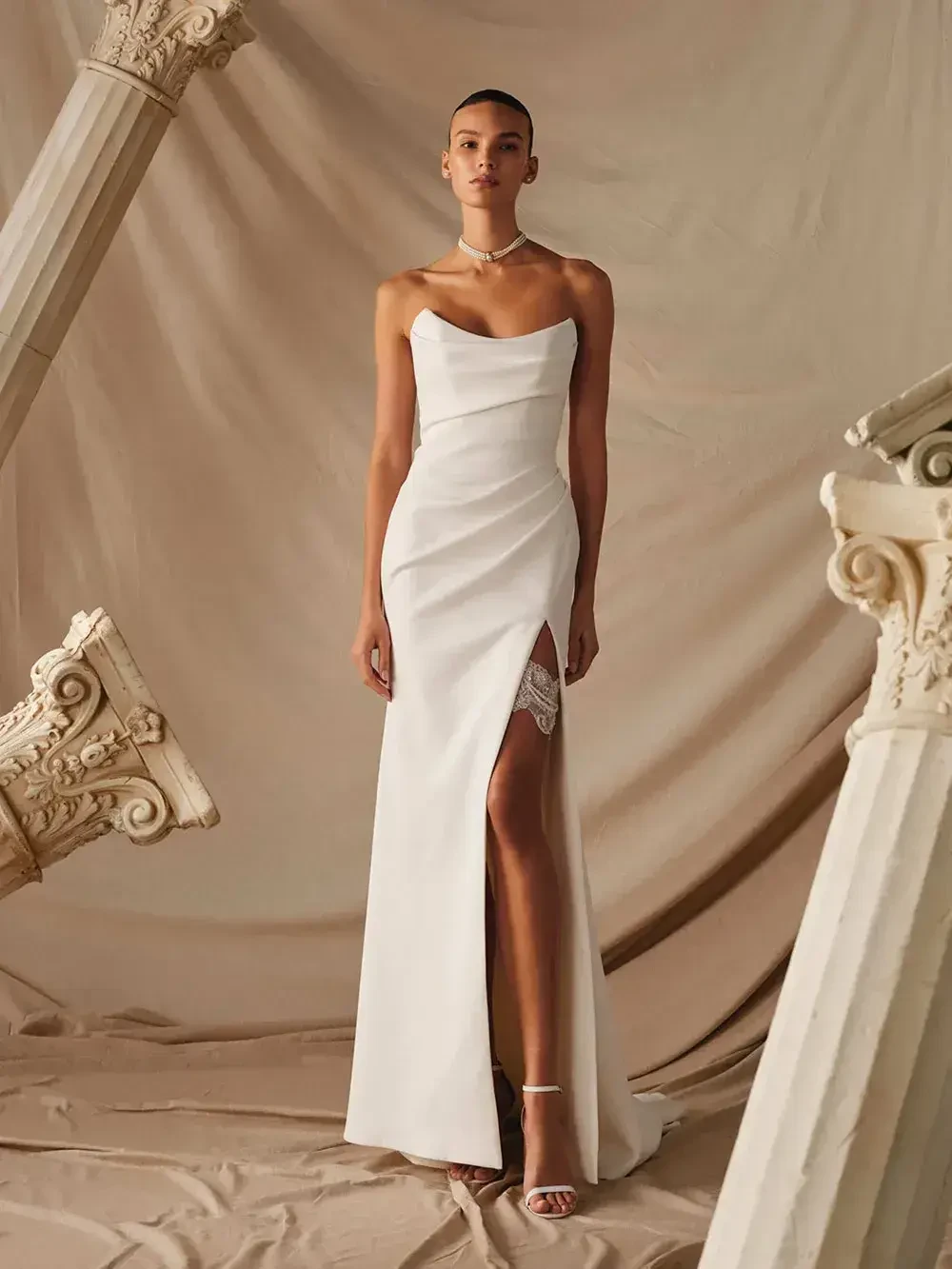 model is wearing a strapless column bridal gown