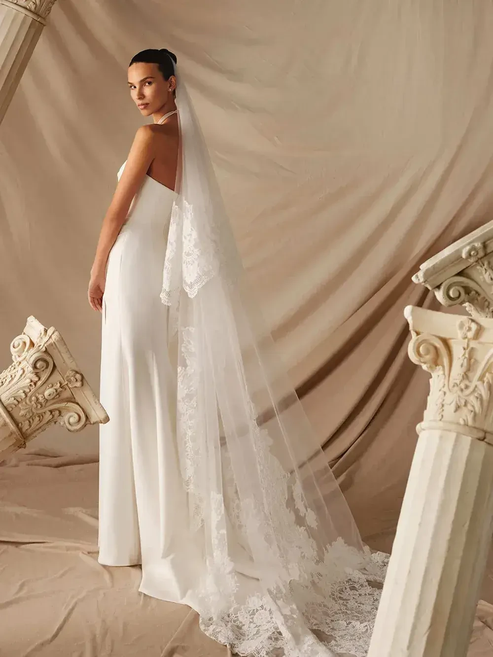 model is wearing a strapless column bridal gown