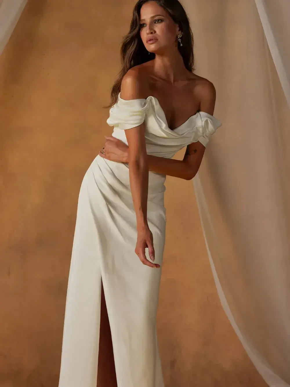model is wearing an off the shoulder bridal gown